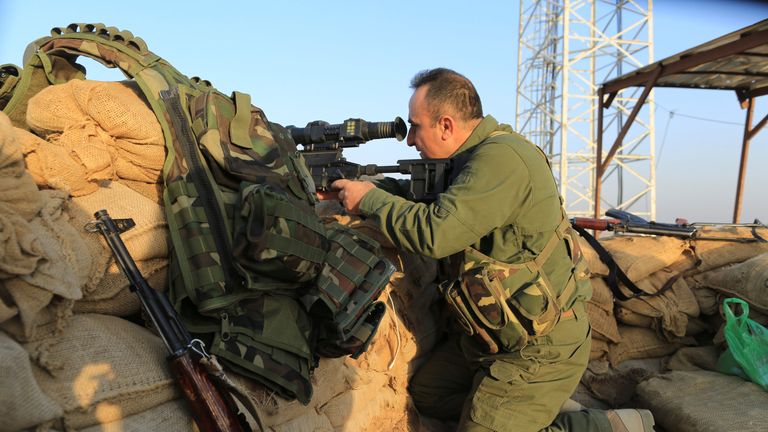 A Kurdish Peshmerga fighter takes position in front of an Islamic State militants' position outside the town of Naweran