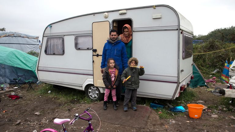 Iraqi migrants Ibrahim, his wife Ashty, their children Mandy (L) and Muhammad (R) pose outside their caravan in the "New Jungle" make-shift camp as unseasonably cool temperatures arrive in Calais, northern France, October 15, 2015. More than 3,500 people, migrants and refugees are camped in Calais, fleeing war and poverty in the Middle East, Africa and Asia and now living in the jungle. Most of them are hoping to make the crossing to England. REUTERS/Philippe Wojazer TPX IMAGES OF THE DAY