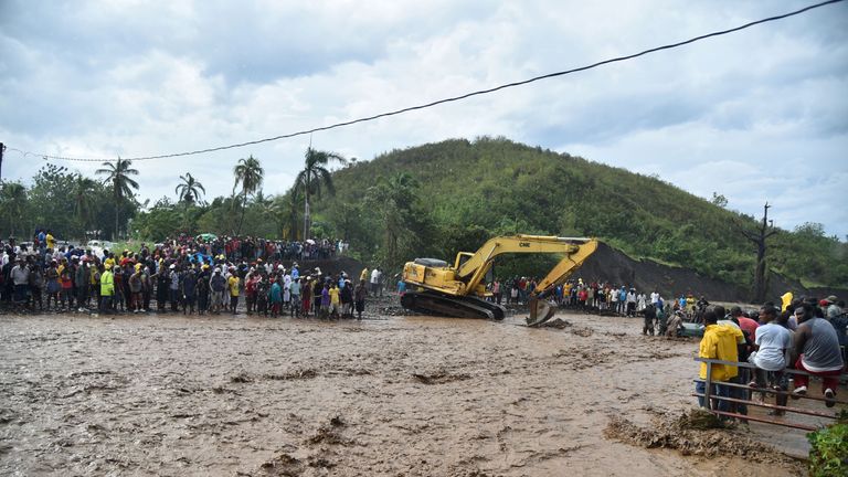 Haitians wait to cross the river La Digue in Petit Goave where the bridge collapsed 