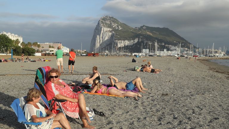 LA LINEA DE LA CONCEPCION, SPAIN - JUNE 22: Beachgoers lie in the sand as the British territory of Gibraltar looms behind the day before the EU Referendum on June 22, 2016 in La Linea de la Concepcion, Spain. Citizens of the United Kingdom and its territories will go to the polls tomorrow in what many expect to be a very tight vote on whether to remain in or leave the European Union. A result is expected early Friday morning. (Photo by Sean Gallup/Getty Images)