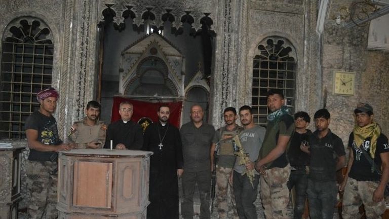 Liberating troops with workers at a Christian church in Bartella, near Mosul, which has been retaken from Islamic State. Pic: A Demand For Action
