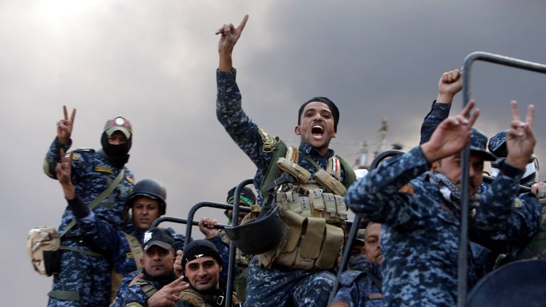 Iraqi security forces gesture in Qayyarah