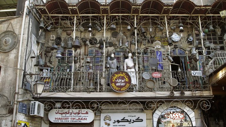 Tourists walk past a trinkets shop in the Jdeideh district of the northern Syrian city of Aleppo June 23, 2010.