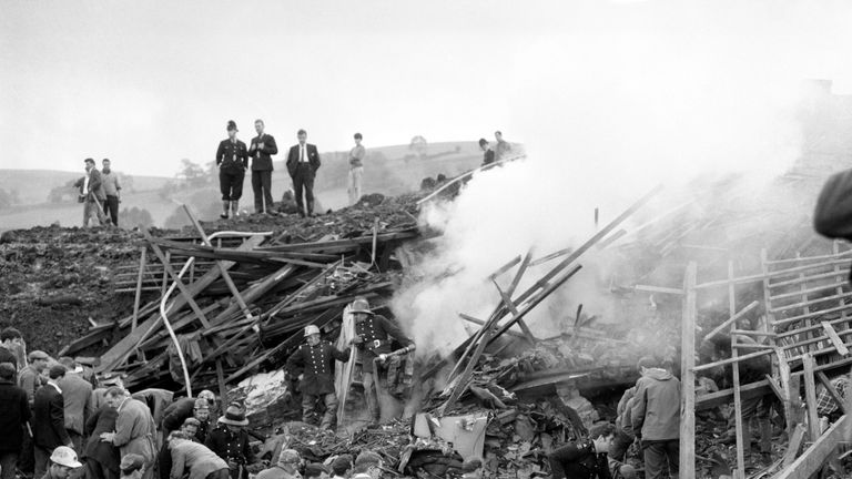 Avec des pelles ou à mains nues, les sauveteurs déchirent la boue et les décombres en enterrant les ruines de l'une des sept maisons englouties par une montagne en mouvement de boue de charbon à Aberfan, près de Merthyr Tydfil, Glamorganshire