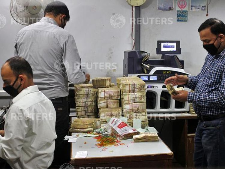 Bank employees count old 500 Indian rupee banknotes inside a bank in Jammu