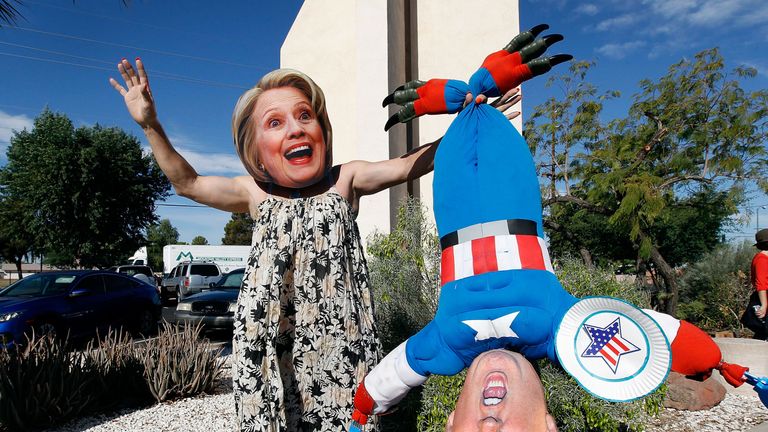 Phoenix, Arizona: Hillary Clinton supporter Jorge Mendez wears a dress and Hillary Clinton mask while holding a makeshift doll of Donald Trump after casting his vote