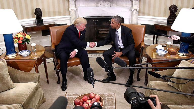 The two shake hands for the camera