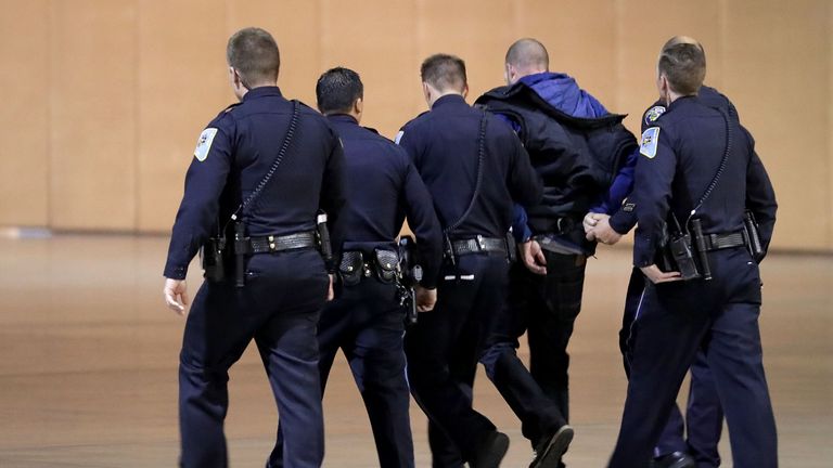 A suspect is led away after Donald Trump had to be bundled off stage at a rally in Nevada