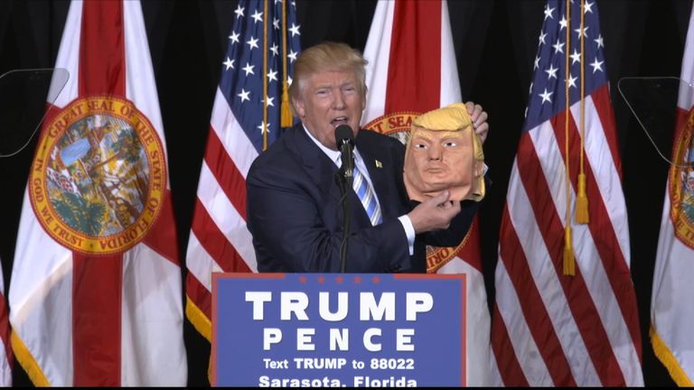 Donald Trump holds up mask of his own face at Florida rally