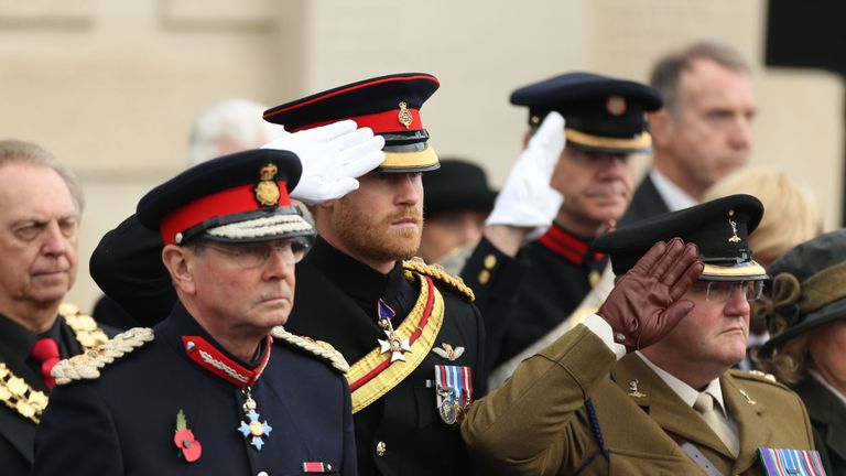Prince Harry salutes during the service at the Armed Forces Memorial
