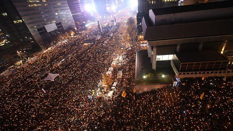 Protesters holding candles march toward the presidential Blue House during an anti-government rally in central Seoul on November 19, 2016, aimed at forcing South Korean President Park Geun-Hye to resign over a corruption scandal