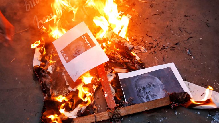 Indian Prime Minister Narendra Modi’s picture burns during a protest