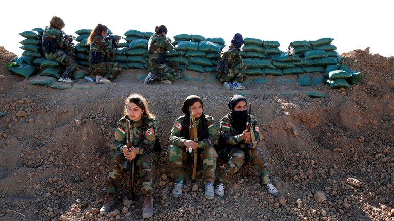 Iranian-Kurdish female fighters hold their weapons during a battle with Islamic State militants in Bashiqa, near Mosul