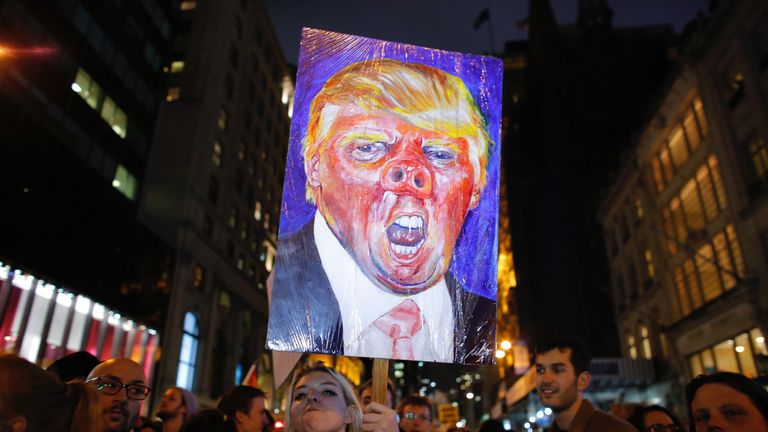 A woman holds a poster as she takes part in a protest against President-elect Donald Trump in New York City