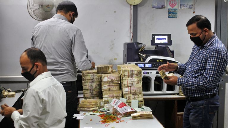 Bank employees count old 500 Indian rupee banknotes inside a bank in Jammu