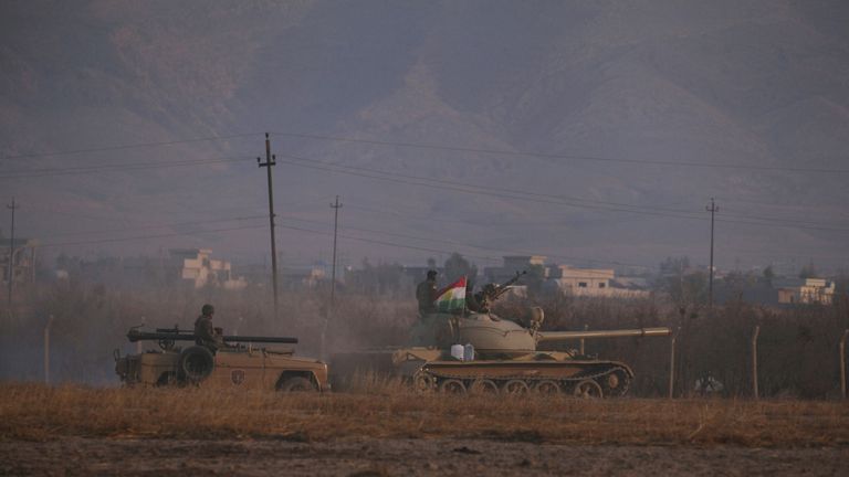Military vehicles drive towards the centre of Bashiqa as the offensive against IS increases