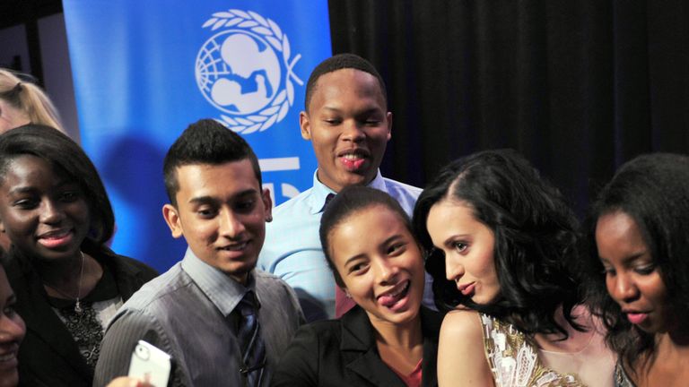 US singer Katy Perry (2nd R) poses with local students after being named a UNICEF goodwill ambassador December 3, 2013 at UNICEF headquarters in New York. AFP PHOTO/Stan HONDA (Photo credit should read STAN HONDA/AFP/Getty Images)
