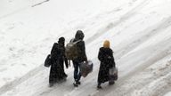 Syrians walk in a snow covered street in the town of Maaret al-Numan, in Syria&#39;s northern province of Idlib, near Aleppo, on December 21, 2016