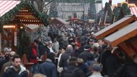 Visitors walk through the reopened Breitscheidplatz Christmas market only a short distance from where three days ago a truck plowed into the market, killed 12 people and injured dozens in a terrorist attacK