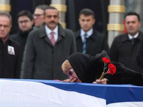 Marina Karlov mourns her husband laying her head on top a flag-wrapped coffin of late Russian Ambassador to Turkey Andrei Karlov before being carried to a plane by Turkish soldiers during a ceremony at Esenboga airport on December 20, 2016 in Ankara. Turkey. Russia&#39;s ambassador to Turkey, Andrey Karlov, was shot dead by a Turkish policeman shouting &#39;Don&#39;t forget Aleppo! Don&#39;t forget Syria&#39; at an art exhibition in the Turkish capital of Ankara