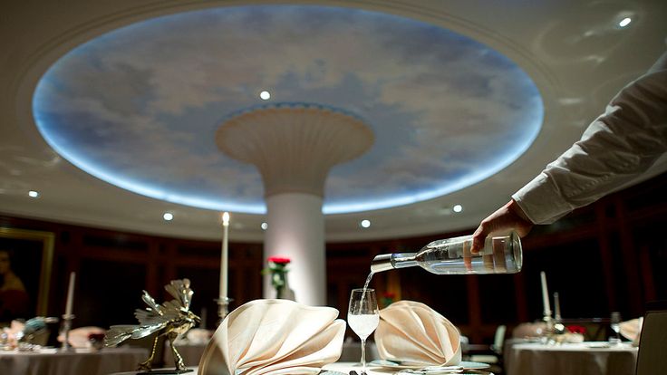 A waiter pours water in a glass at the Lorenz Adlon Esszimmer restaurant