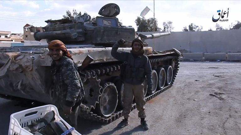 IS fighters with what they say are military vehicles captured in Palmyra