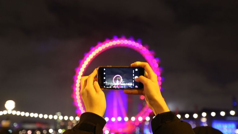 A lucky ticketholder for London's sold-out New Year show takes a photo of the London Eye