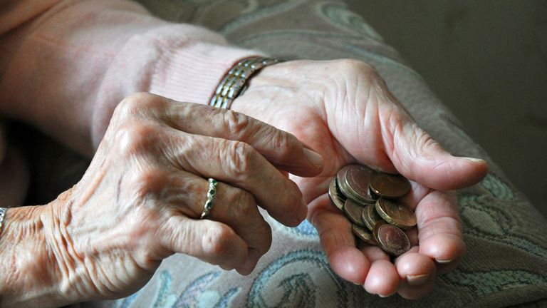 An elderly woman counting loose change