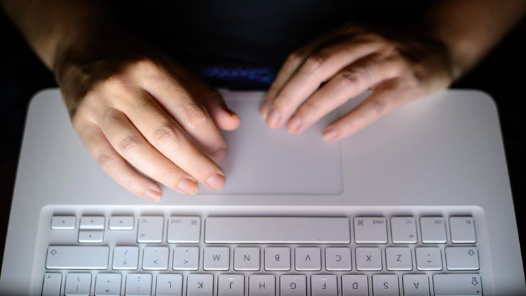 A person uses a laptop keyboard. File picture