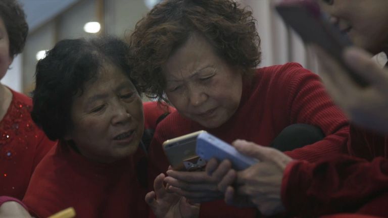 Chinese grandmothers play on their smartphones
