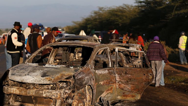 People look at wreckages of burnt out cars engulfed by the fireball