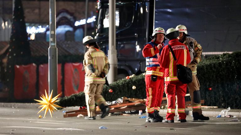 Firefighters discuss what action is needed at the site when a bus crashed into a Christmas market
