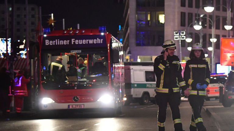 Firefighters walk near the site where a truck speeded into a christmas market in Berlin, on December 19, 2016 killing nine persons and injuring at least 50 people.
