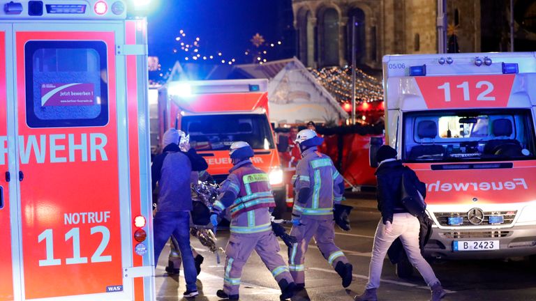 Rescue workers stand near the Christmas market in Berlin