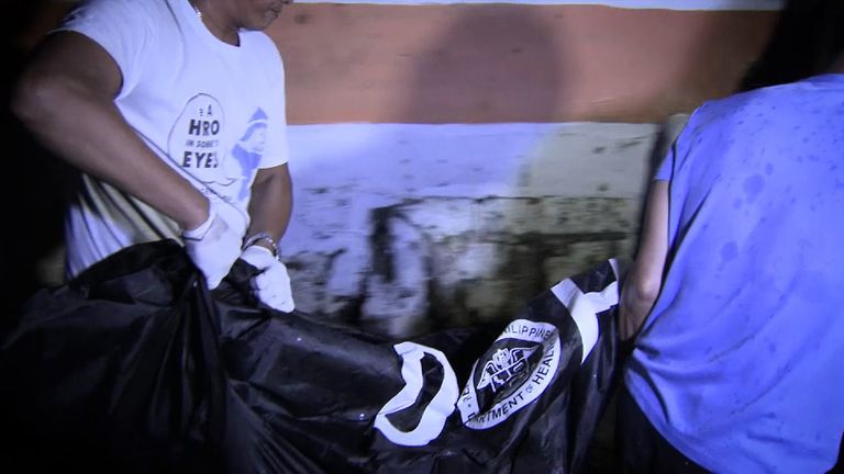 A body bag is carried away after a killing in Manila