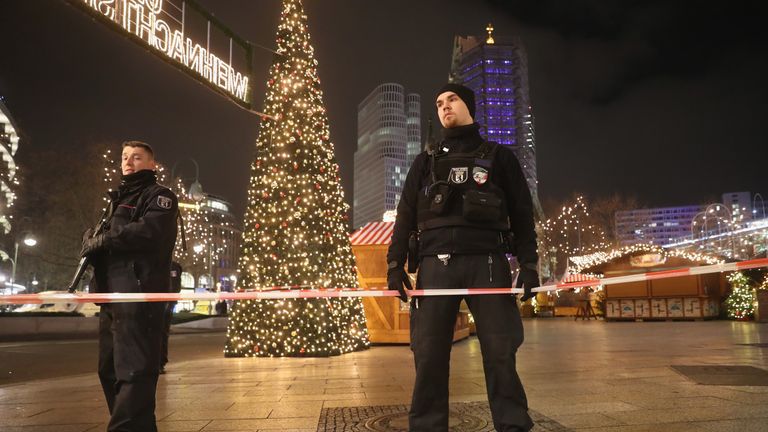 Security stand and guard the area after a lorry truck ploughed through a Christmas market in Berlin, Germany.