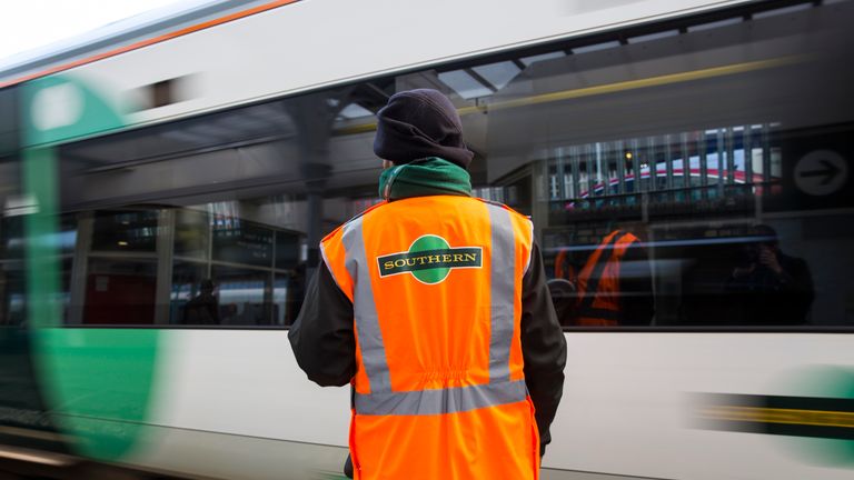 A Southern rail conductor looks on as a Southern rail train leaves East Croydon station on October 18, 2016 in London, England