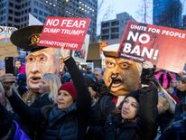 Protestors hold up signs in front of effigies of U.S. President Donald Trump and Russian President Vladimir Putin during in a demonstration on January 29, 2017 in Seattle, Washington, against Trump's executive order banning Muslims from certain countries. The rally was one of several in the area over the weekend