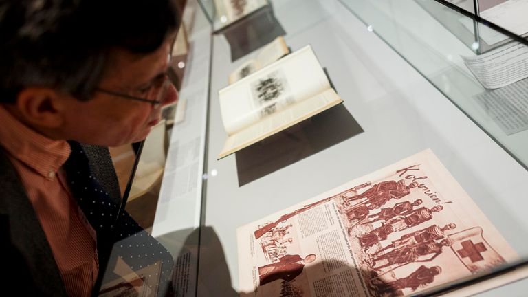 A visitor looks at documents related to the Herero Massacre during an exhibition