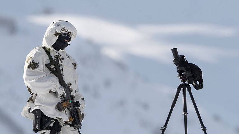 A police sniper stands guard over the Davos Congress Centre