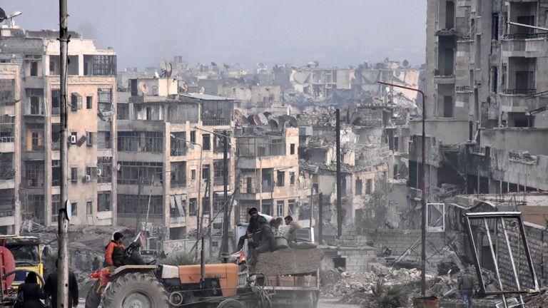 Workers clear debris in a former rebel-held district of Aleppo