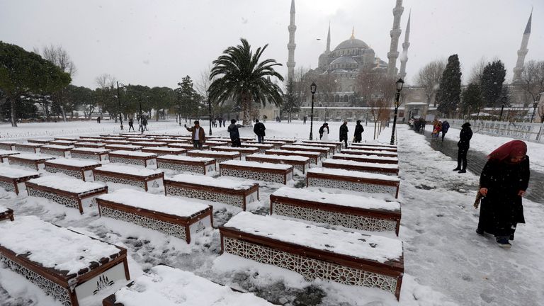 People stroll at the snow-covered Sultanahmet square in Istanbul