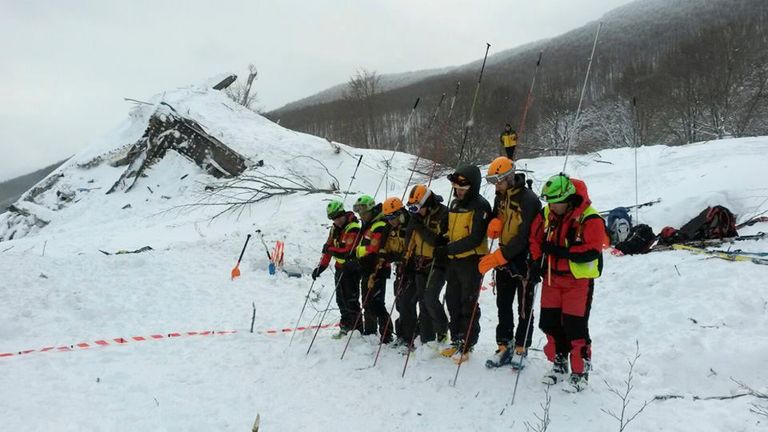 Rescue teams probe the snow in the search for survivors