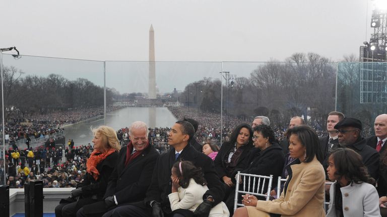 Barack Obama cuddles his daughter Malia in front of huge crowds at his inauguration