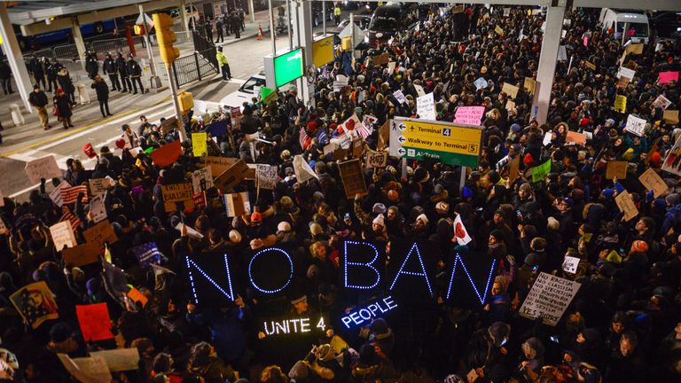 Demonstrators hold signs during a rally against a ban on Muslim immigration at San Francisco International Airport