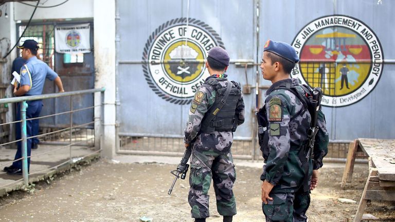 Armed police stand guard at the gates of the district jail