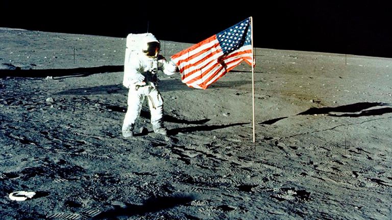 Charles Conrad Jr stands with the US flag on the lunar surface during the Apollo 12 mission in 1969