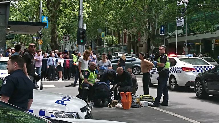 Members of the public watch as police and emergency services attend to an injured person after a car hit pedestrians in central Melbourne, Australia, January 20, 2017