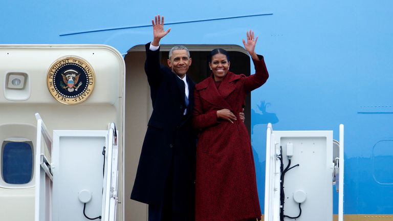 Former president Barack Obama waves with his wife Michelle as they board Special Air Mission 28000