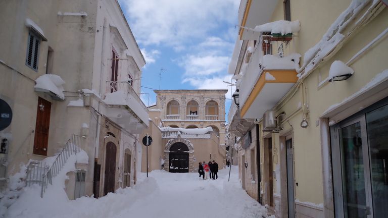 People walk in a street of Santeramo in Colle after snowfalls near Bari in the Puglia region in the south of Italy